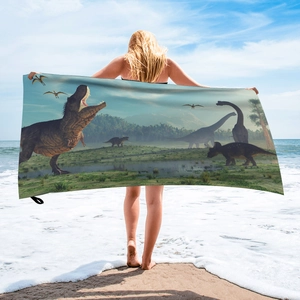 Detailed view of microfiber beach towel with 3D cartoon dinosaur print on a sunny beach