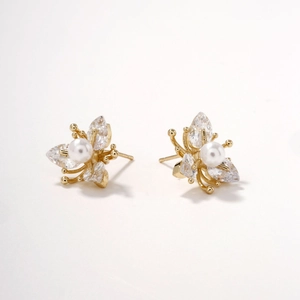 Elegant gold flower stud earrings with marquise-cut gems and center pearl on white background