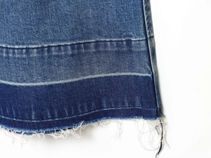 Detail of high-waisted wide-leg jeans showing dark blue denim texture and frayed hem