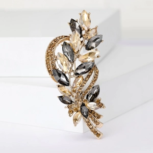 Detail of crystal barley brooch with amber and smoke grey marquise stones on gold base