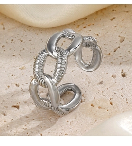 Close-up of silver-tone chain ring with industrial style on textured stone background