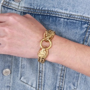 Men's punk style gold lion head bracelet with round clasp worn on denim sleeve