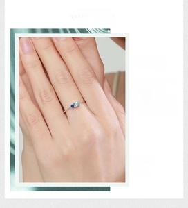 Close-up of minimalist s925 silver ring featuring dual blue round-cut gemstones on slim band