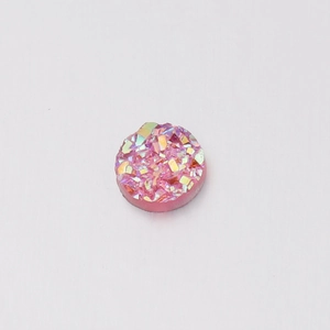 Close-up of pink round resin base with iridescent starry crystals and textured surface