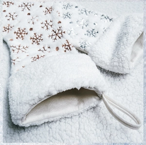 Dettaglio della calza di Natale in peluche bianca con ricamo di fiocchi di neve paillettes