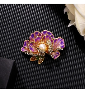 Macro detail of enamel peony brooch with pearl and crystals on elegant black background