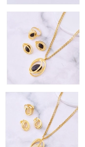 Detail of gold jewelry set with oval turquoise pendants on white marble background