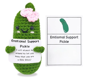 Macro shot of green crochet cucumber doll with pink bow and emotional support card