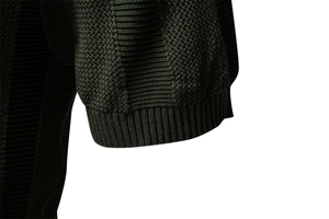 Detail showing the dark green honeycomb knit fabric and ribbed cuff of the men's polo sweater