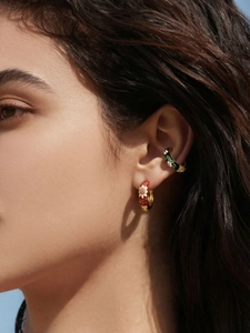 Detailed close-up of colorful enamel flower earrings with gold finish on a model ear