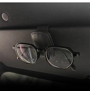 Close-up of the black leather car sunglasses holder clipped onto a sun visor with glasses
