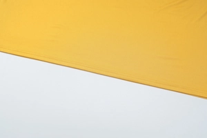 Detail of yellow knit fabric showing premium double-needle stitching on the dress hem