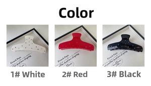 Detail view of large acetate hair claws in white, red, and black with colorful rhinestones