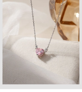 Macro shot of pink heart pendant necklace with silver chain and side diamond accents