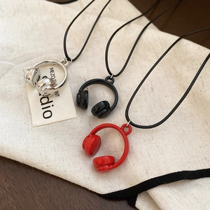 Detail of headphone pendants in silver, black, and red colors with metallic finish