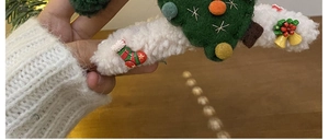Detail of plush Christmas hair claw clip with tree and sock charms for festive hair styling
