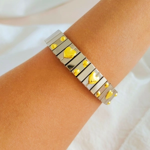 Detail of silver modular stretch bracelet with gold heart and dot relief charms