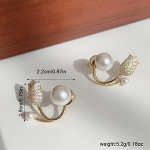 Close-up of elegant tulip pearl earrings with sparkling crystals and golden finish
