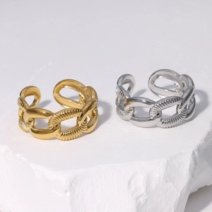Minimalist gold and silver chunky chain rings on a stone surface for a modern industrial look