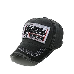 Detail of vintage charcoal cotton baseball cap with distressed brim and New York embroidery