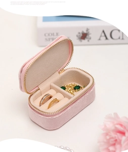 Pink velvet travel jewelry box detail showing ring slots and zip closure design