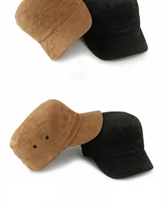Detail of military flat caps in brown and black faux suede with metal eyelets