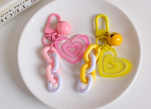 Detail of creative double heart keychains with colorful bells and matte lobster clasps