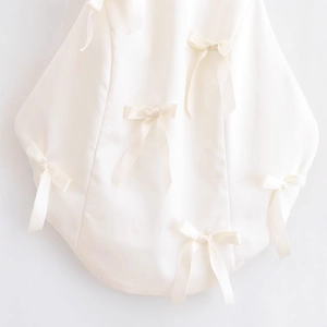 Elegant off-shoulder halter top in creamy white satin featuring multiple bow decorations