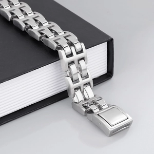 Close-up of industrial silver stainless steel chain bracelet on a black book