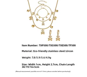 Detail view of gold stainless steel jewelry set with bear and heart charms and zircons