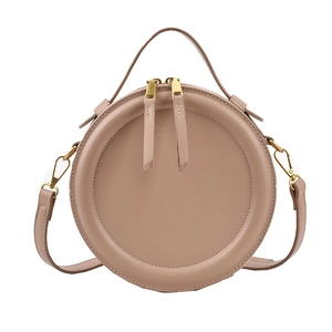 Retro minimalist round crossbody bag in beige leather with top handle and gold zipper