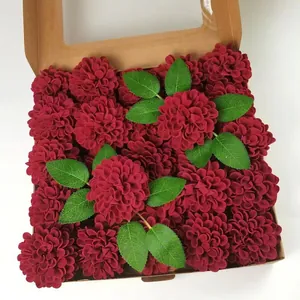 Detailed top view of deep red artificial rose gift box with velvet petals and green leaves