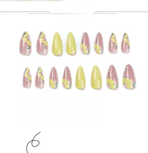 Detail of 24pcs yellow and pink almond press-on nails with heart and floral patterns