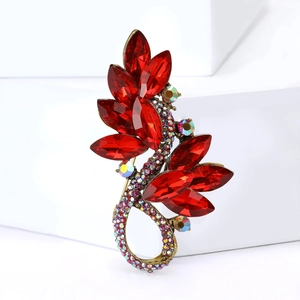 Close-up of elegant red crystal leaf brooch with golden alloy base and iridescent accents