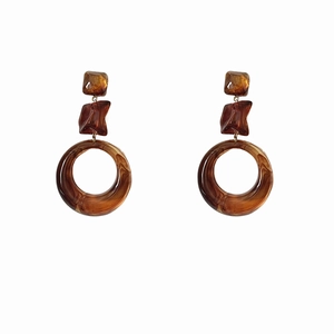 Vintage amber resin hollow geometric earrings with silver needles on white background