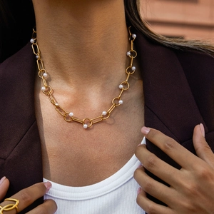 Close-up of 18K gold stainless steel chain necklace with pearls on a model wearing a suit