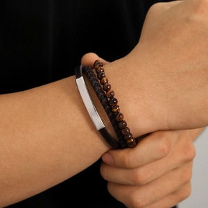 Close-up of men's vintage leather bracelets set with tiger eye beads and metal plate