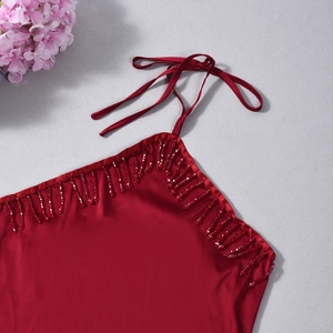 Détail du haut dos nu en satin rouge avec franges en perles et col à nouer délicat
