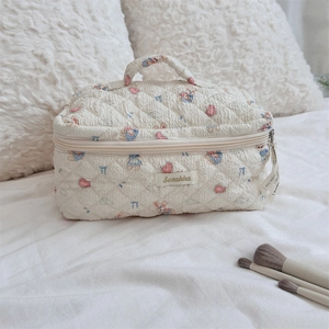 Detailed macro view of quilted cream makeup bag with cute cartoon rabbit patterns