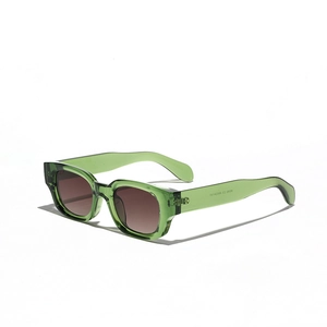 Modern green transparent cat-eye sunglasses with dark gradient lenses at 45-degree angle