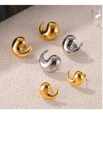 Macro shot of polished gold and silver water-drop geometric stud earrings on a beige surface