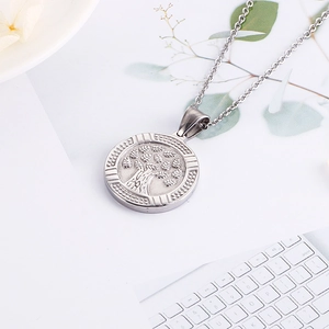 Detailed close-up of a silver stainless steel tree of life pendant on a round charm