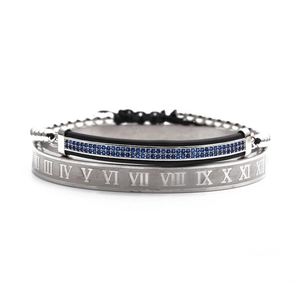 Detail von silbernem Armreif mit römischen Zahlen und schwarzem Armband mit blauen Zirkonia