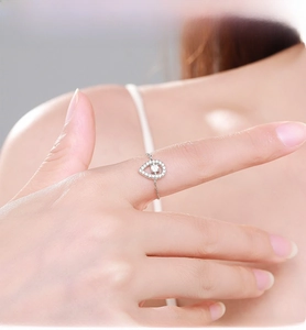 Macro detail of S925 silver chain ring with teardrop zirconia setting on finger