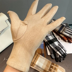 Dettaglio del guanto invernale beige scamosciato touch con motivo a quadri fashion