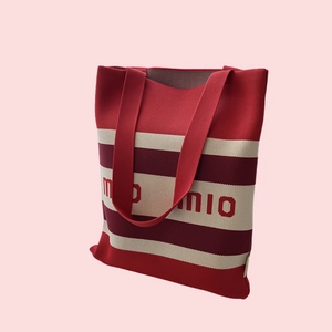 Macro shot of striped knitted tote bag texture and integrated letter weaving detail