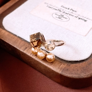 Detailed close-up of a vintage rose gold ring with brown crystal and elegant pearls