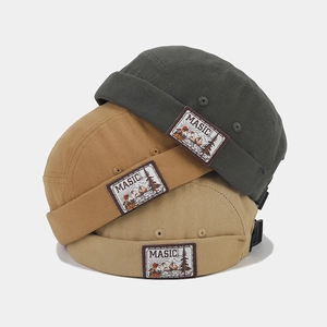 Detail of three retro docker caps showing canvas texture and mountain patch logo