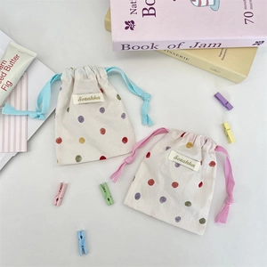 Detail of cotton linen drawstring storage bags with blue and pink polka dot patterns