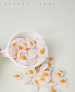 Miniature PVC fried egg props pouring from a ceramic spoon for dollhouse decoration